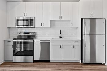 a kitchen with white cabinets and stainless steel appliances